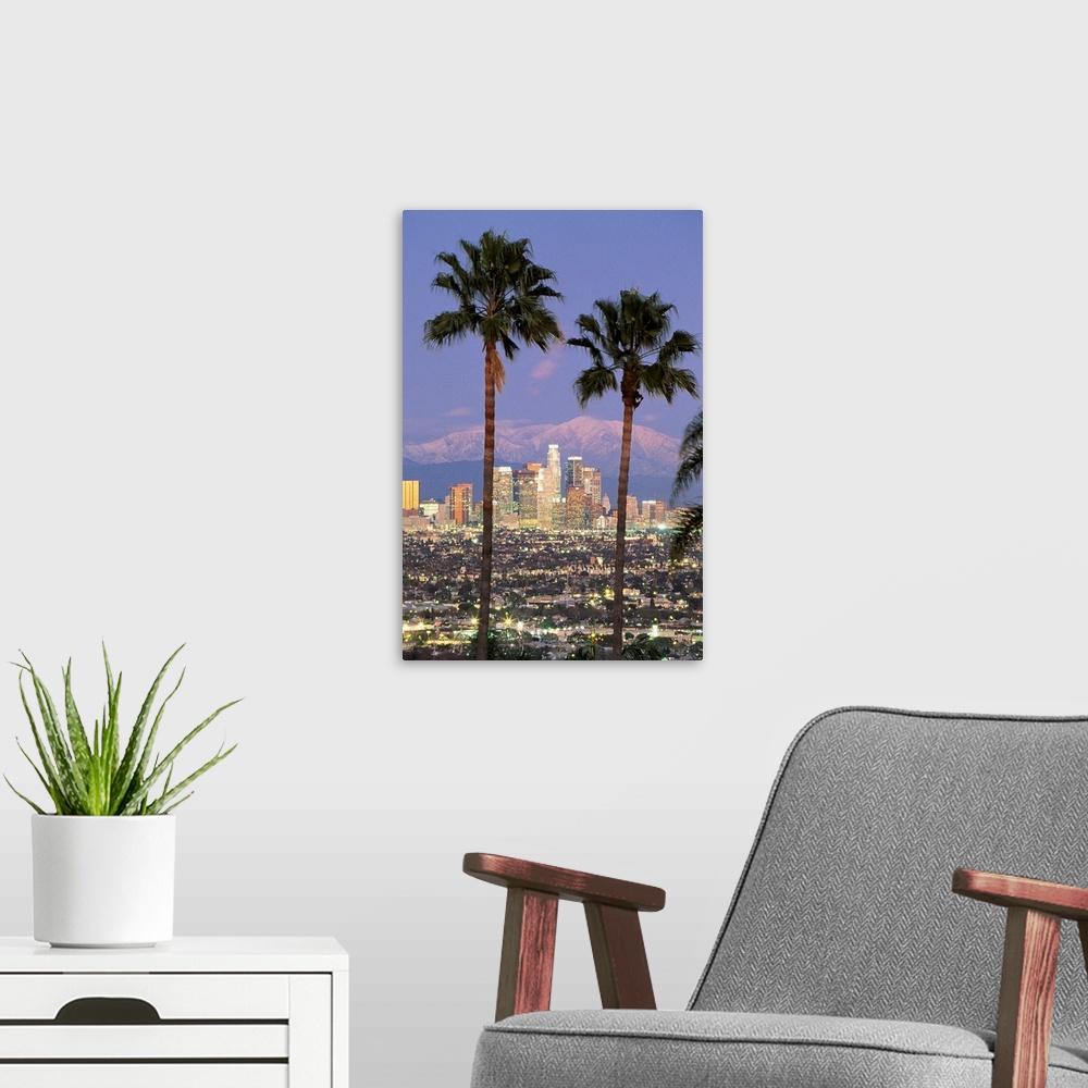 A modern room featuring A vertical photograph of skyscrapers in the Los Angelesos skyline framed by two palm trees and mo...
