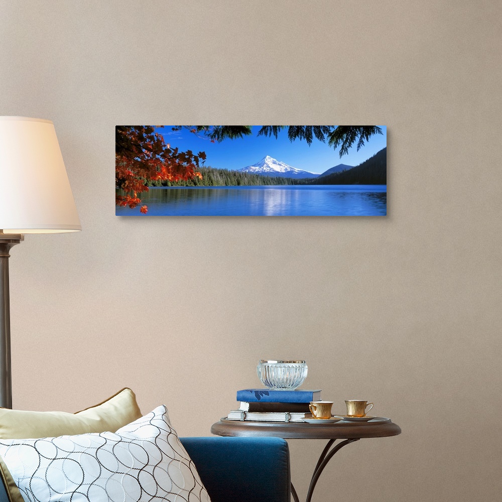 A traditional room featuring In the wilderness a mountain peak reflects in a lake surrounded by trees on this panoramic wall art.