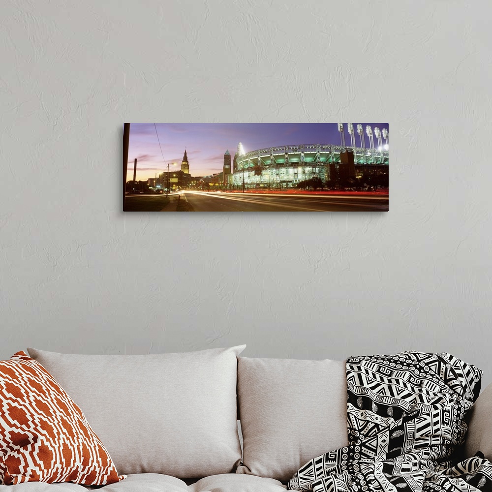 A bohemian room featuring Panoramic photograph of sports arena light up at night with city skyline in the distance.