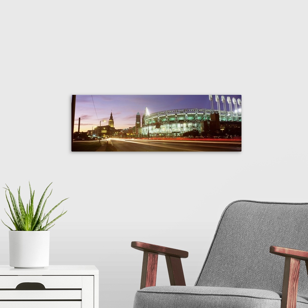 A modern room featuring Panoramic photograph of sports arena light up at night with city skyline in the distance.