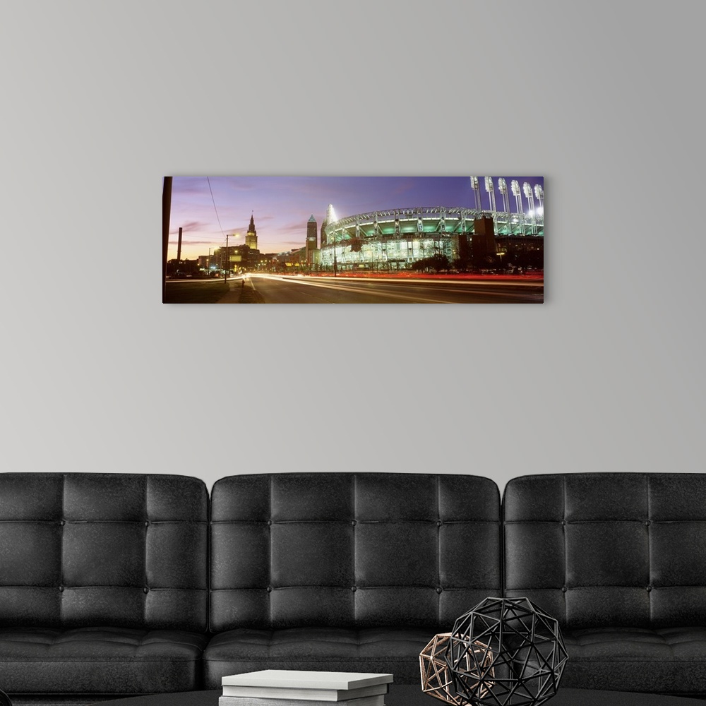 A modern room featuring Panoramic photograph of sports arena light up at night with city skyline in the distance.