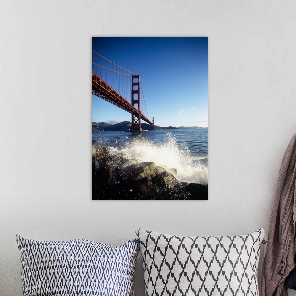 A bohemian room featuring Huge photograph displays a rocky shoreline being beaten with water from the surrounding bay in th...