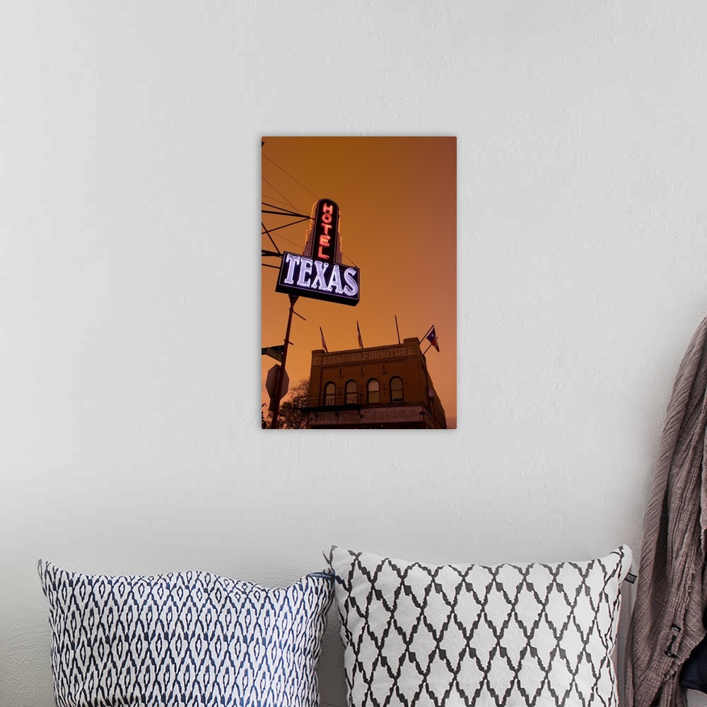 A bohemian room featuring A hotel sign is illuminated under a sunset sky and photographed from below with a view of a furni...