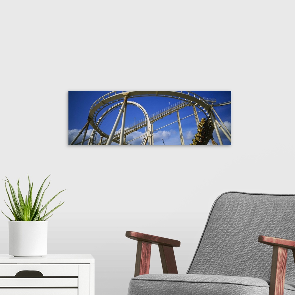 A modern room featuring Low angle view of a rollercoaster in an amusement park