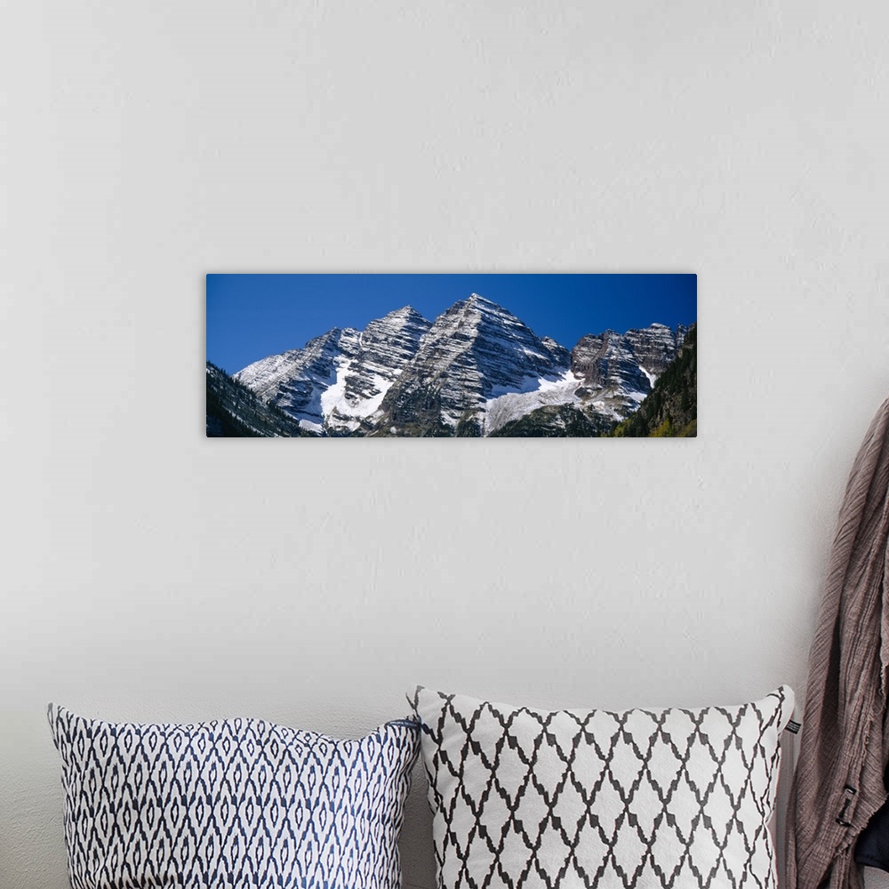 A bohemian room featuring Panoramic photo on canvas of rugged mountains with snow on them.
