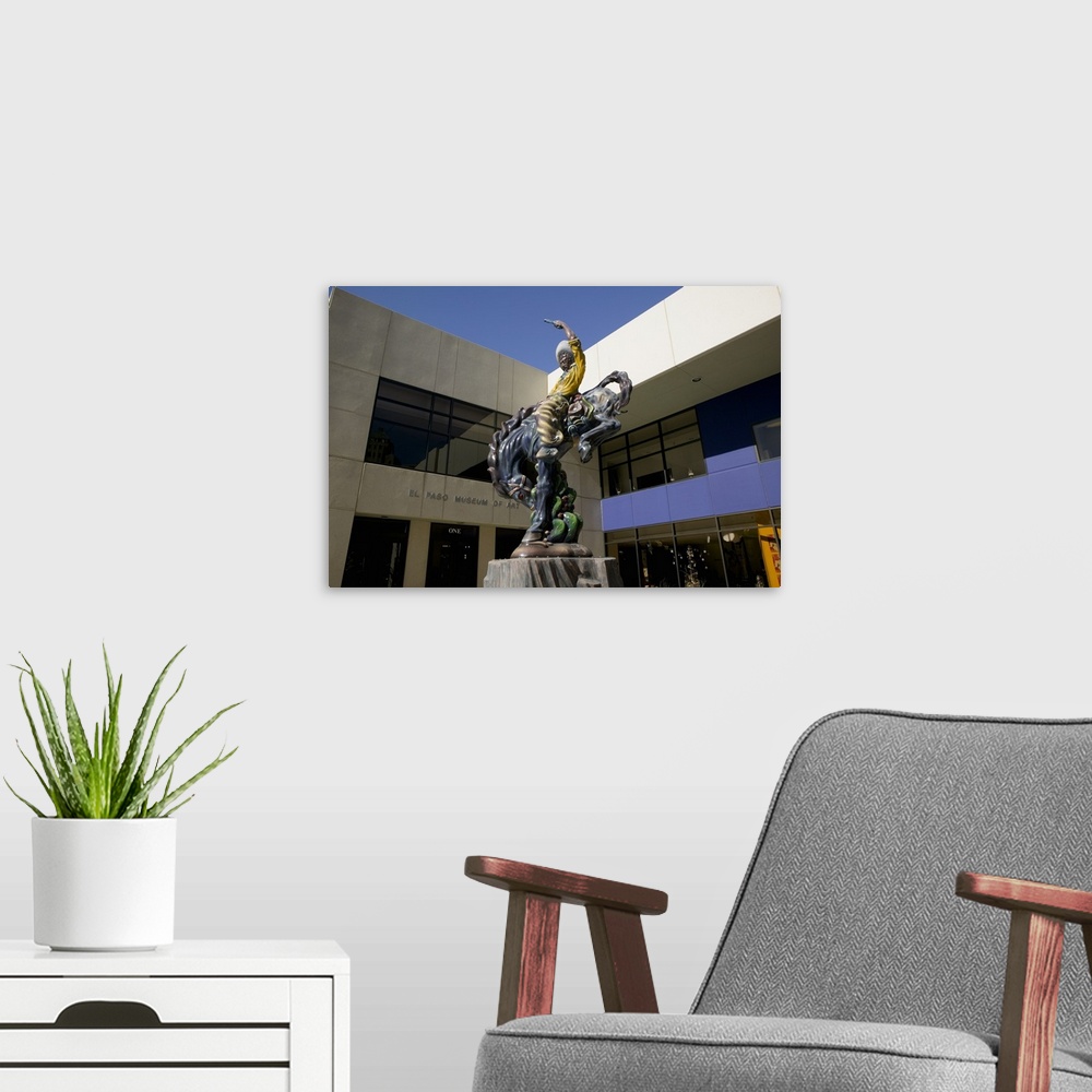 A modern room featuring Low angle view of a statue of a cowboy on a bucking bronco in front of a museum, El Paso Museum O...