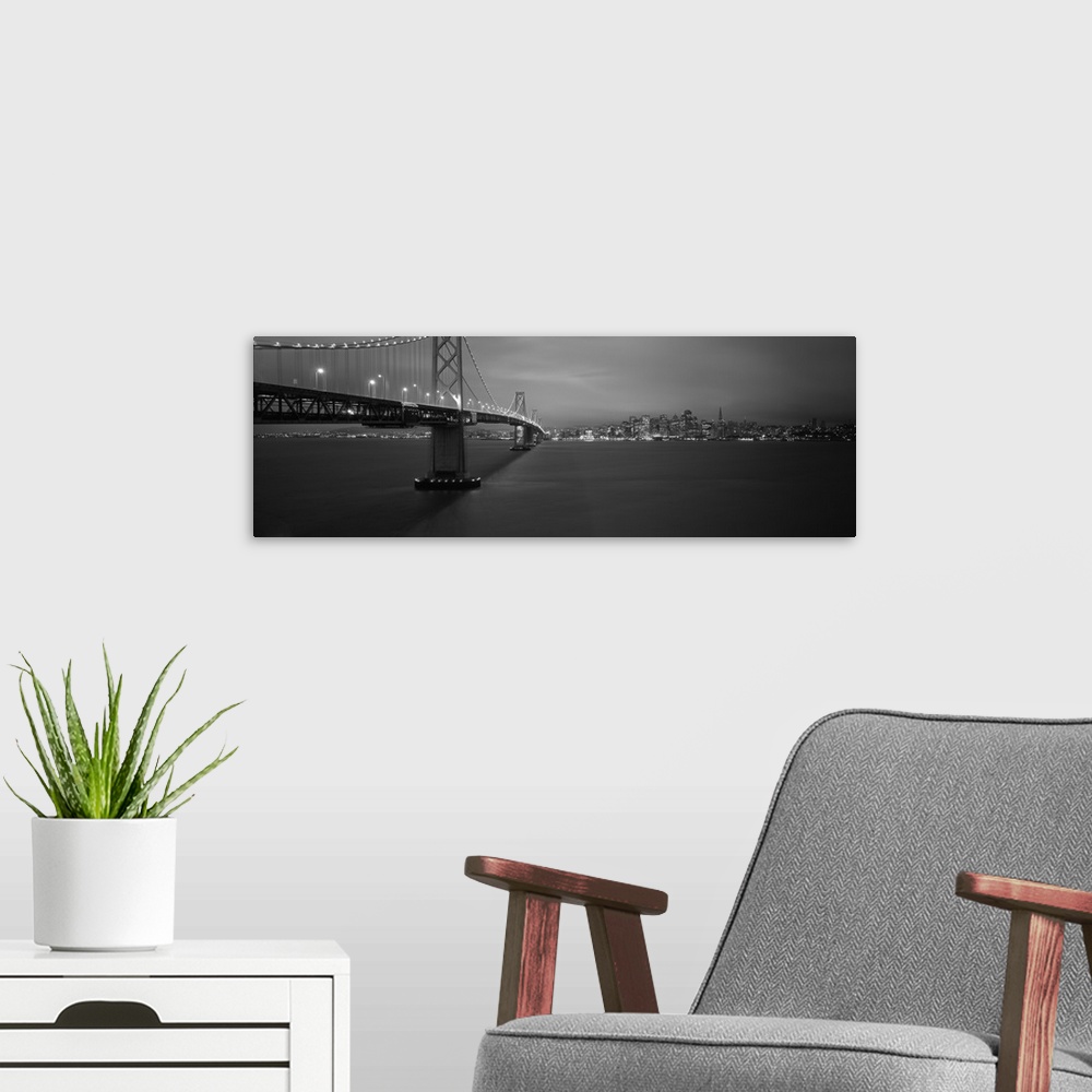 A modern room featuring Low angle view of a suspension bridge lit up at night Bay Bridge San Francisco California