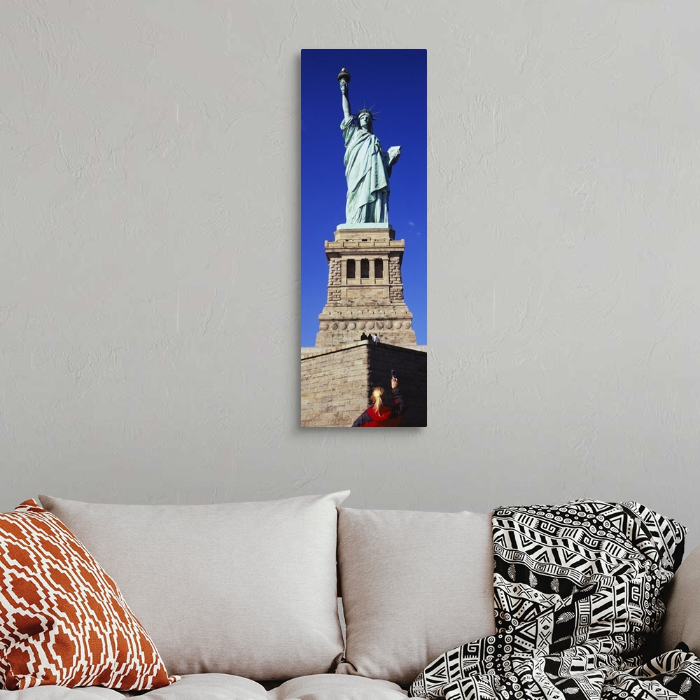 A bohemian room featuring Low angle view of a tourist taking a picture of a statue, Statue of Liberty, Liberty State Park, ...