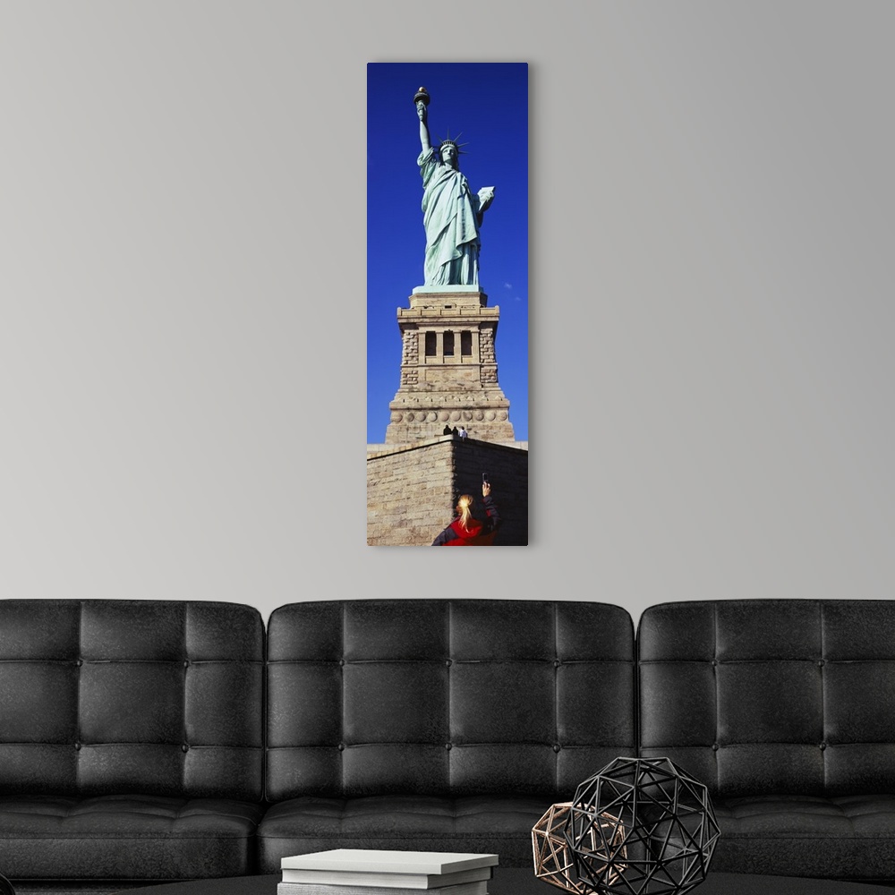 A modern room featuring Low angle view of a tourist taking a picture of a statue, Statue of Liberty, Liberty State Park, ...