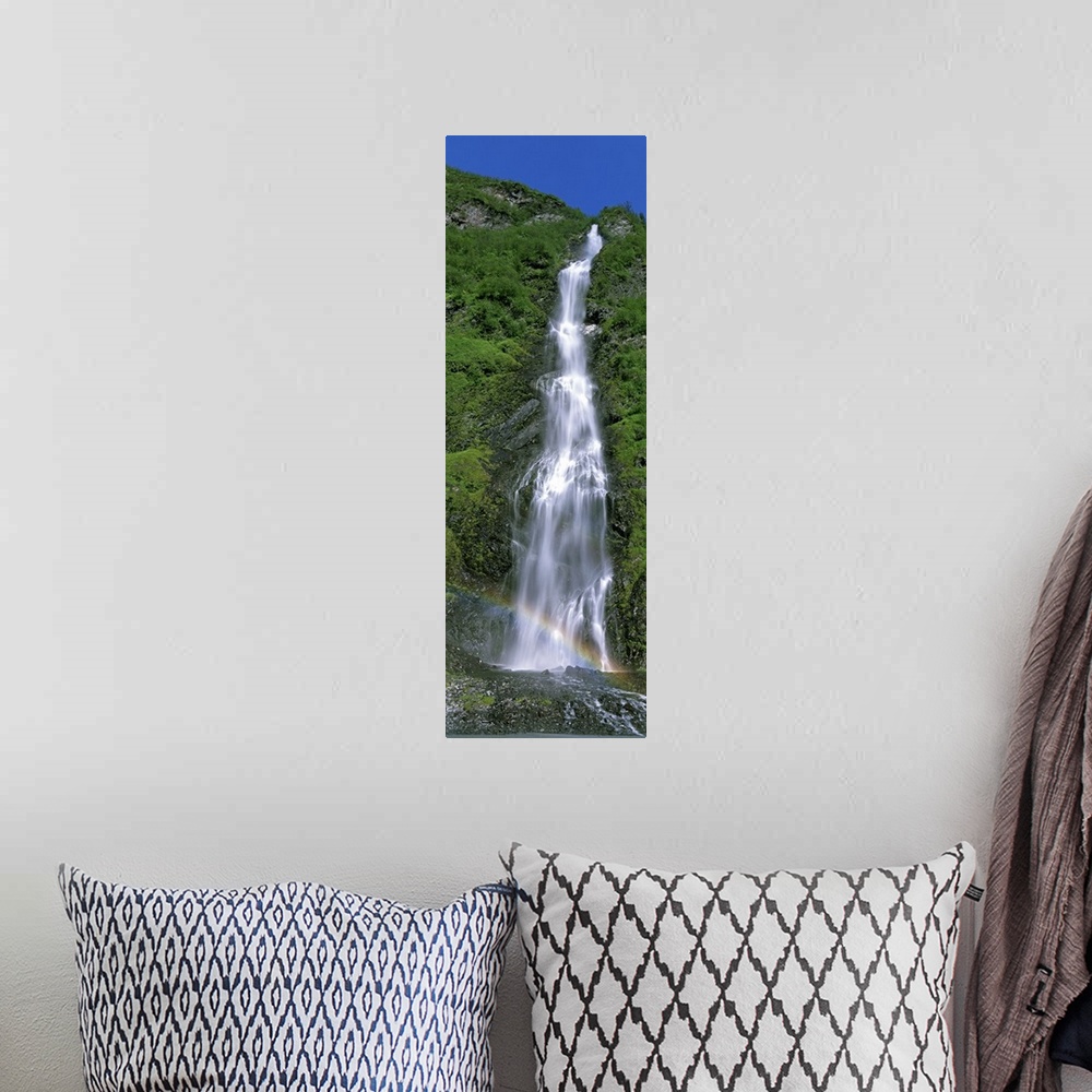 A bohemian room featuring Vertical panoramic photograph of water cascading over rocks with small rainbow at the bottom.