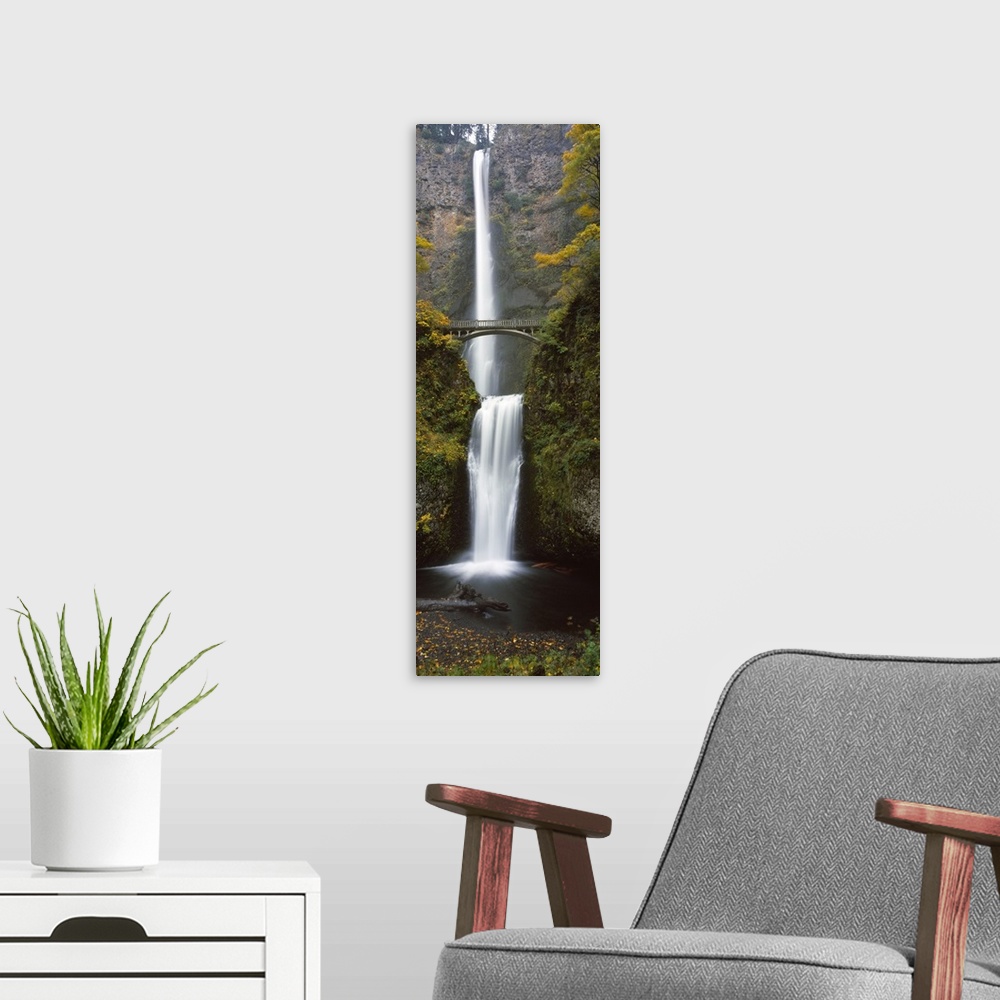 A modern room featuring Vertical panoramic photograph of two large waterfalls, one feeding in to the other, and an arched...