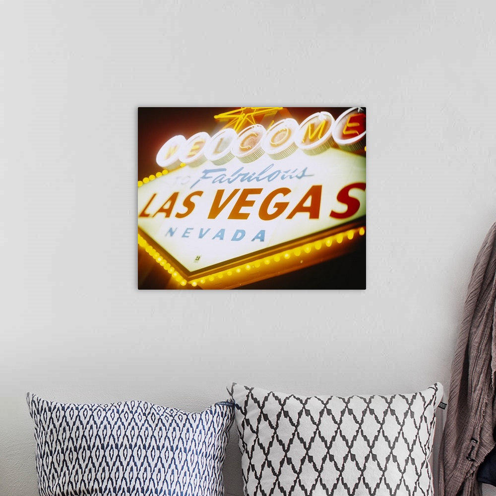 A bohemian room featuring Large photograph focuses on a close-up of the famous neon sign somebody can see as they enter the...