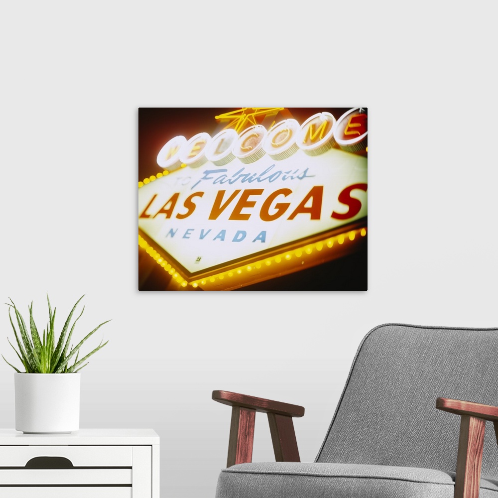 A modern room featuring Large photograph focuses on a close-up of the famous neon sign somebody can see as they enter the...