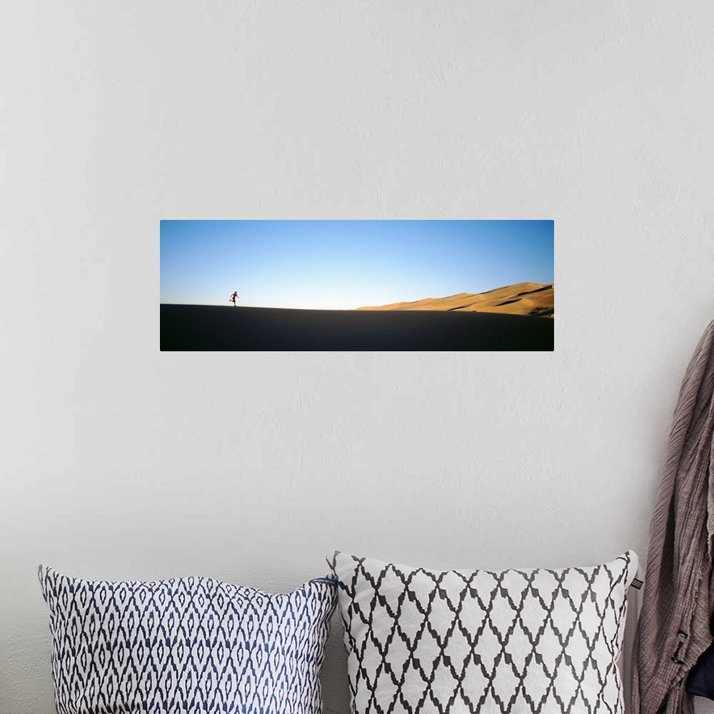 A bohemian room featuring Low angle view of a woman running in the desert, Great Sand Dunes National Monument, Colorado