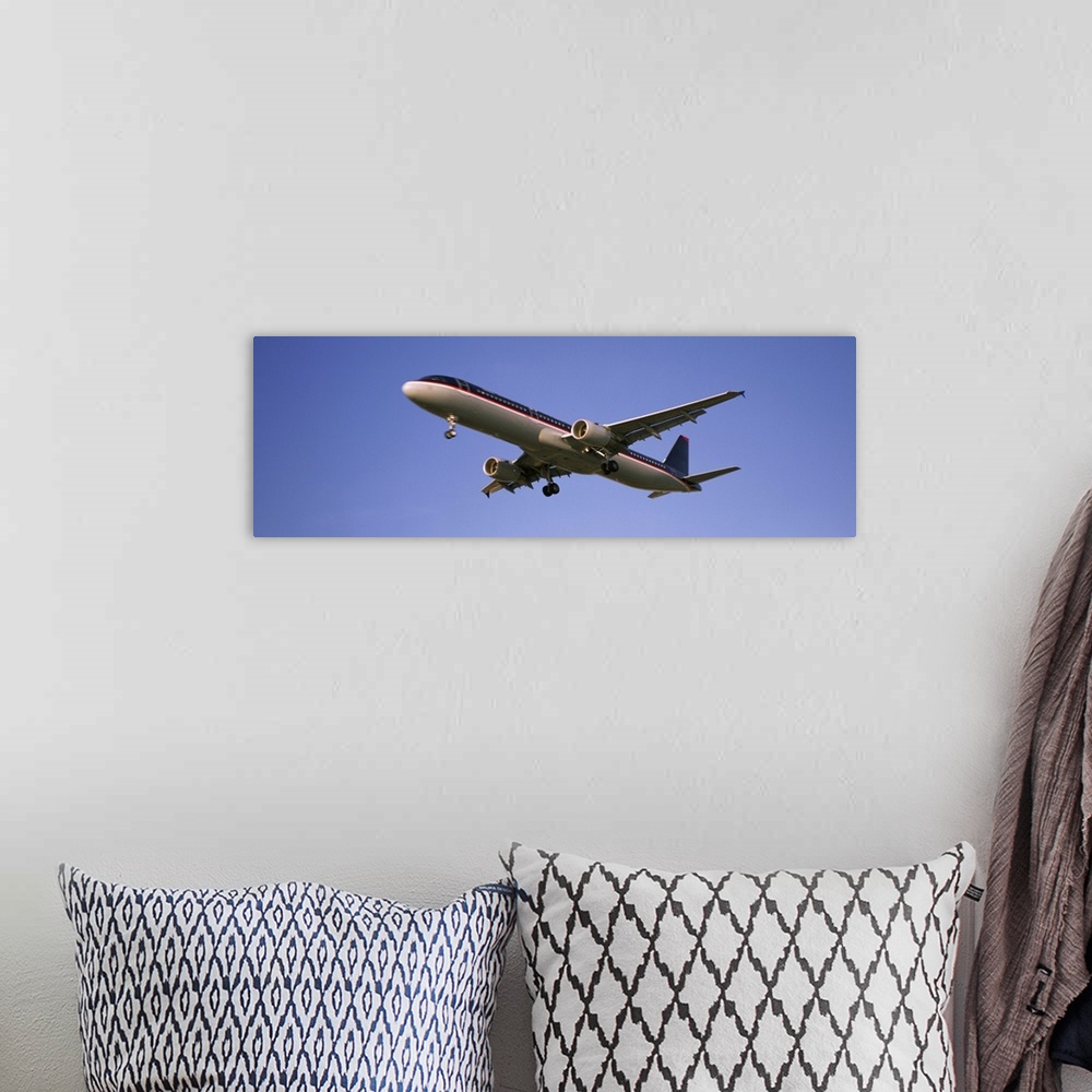 A bohemian room featuring Low angle view of an airplane flying