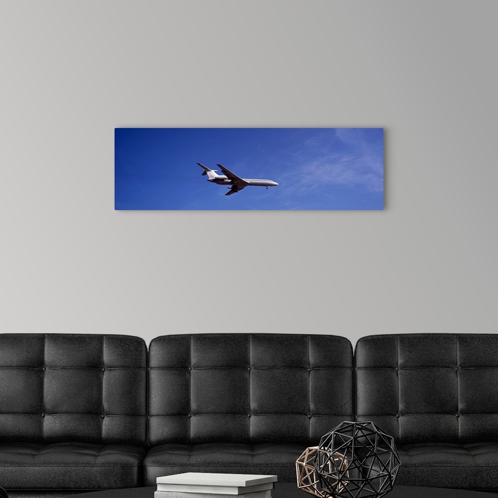 A modern room featuring Low angle view of an airplane flying, Tupolev Tu-154