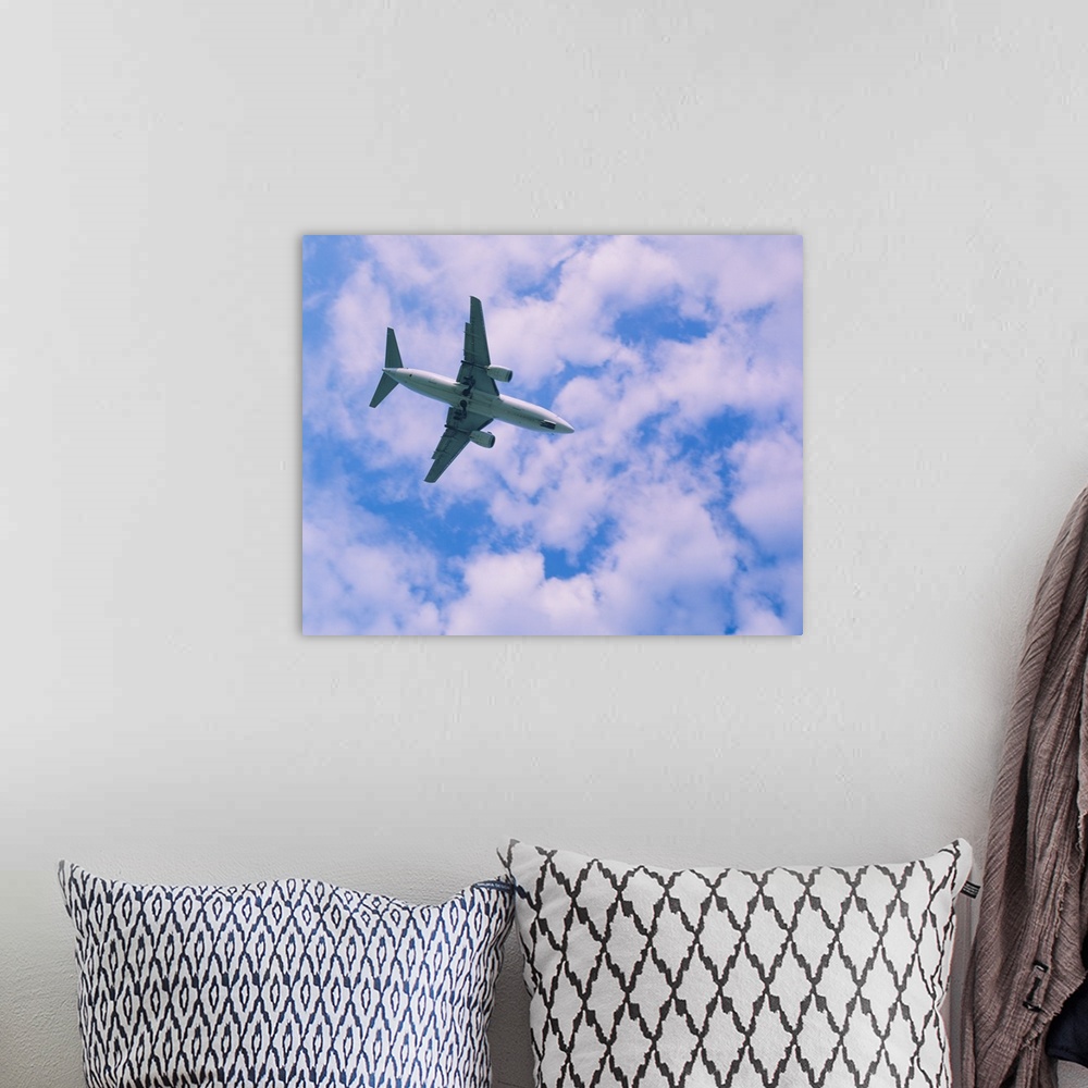 A bohemian room featuring Low angle view of an airplane in flight