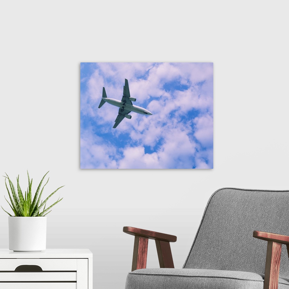 A modern room featuring Low angle view of an airplane in flight