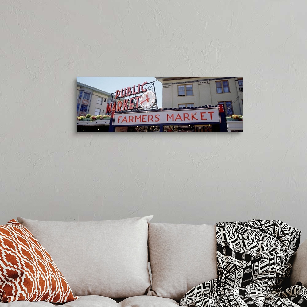 A bohemian room featuring Long canvas print of the Farmer's Market sign in Seattle with the entrance seen below.