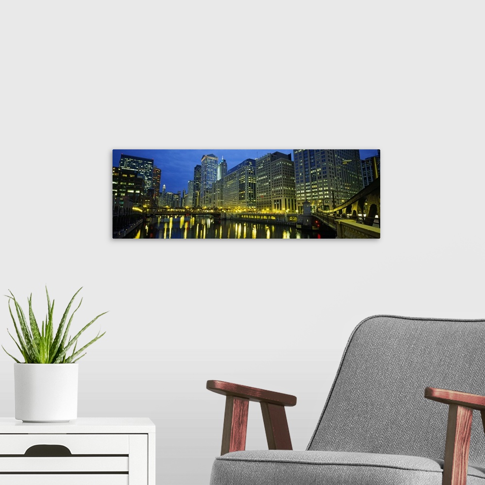 A modern room featuring Long canvas of the Chicago River with the city lit up around it.