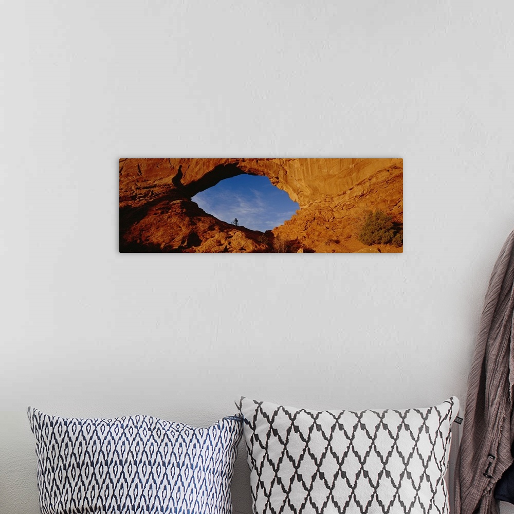 A bohemian room featuring Giant, horizontal, wide angle photograph of the side of a mountain in Utah.  There is a mountain ...