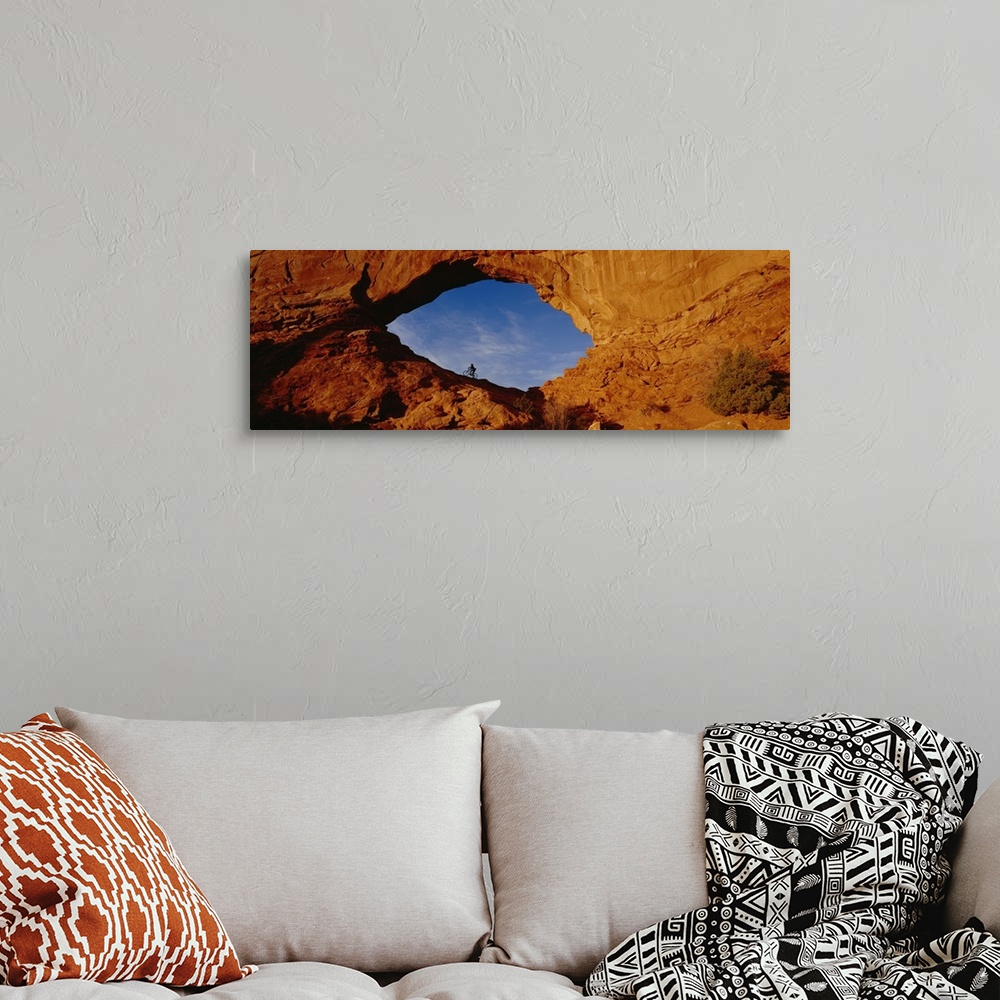 A bohemian room featuring Giant, horizontal, wide angle photograph of the side of a mountain in Utah.  There is a mountain ...