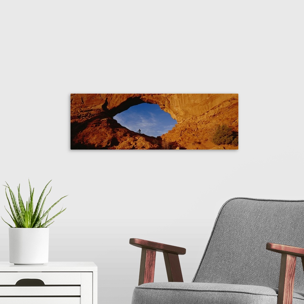 A modern room featuring Giant, horizontal, wide angle photograph of the side of a mountain in Utah.  There is a mountain ...