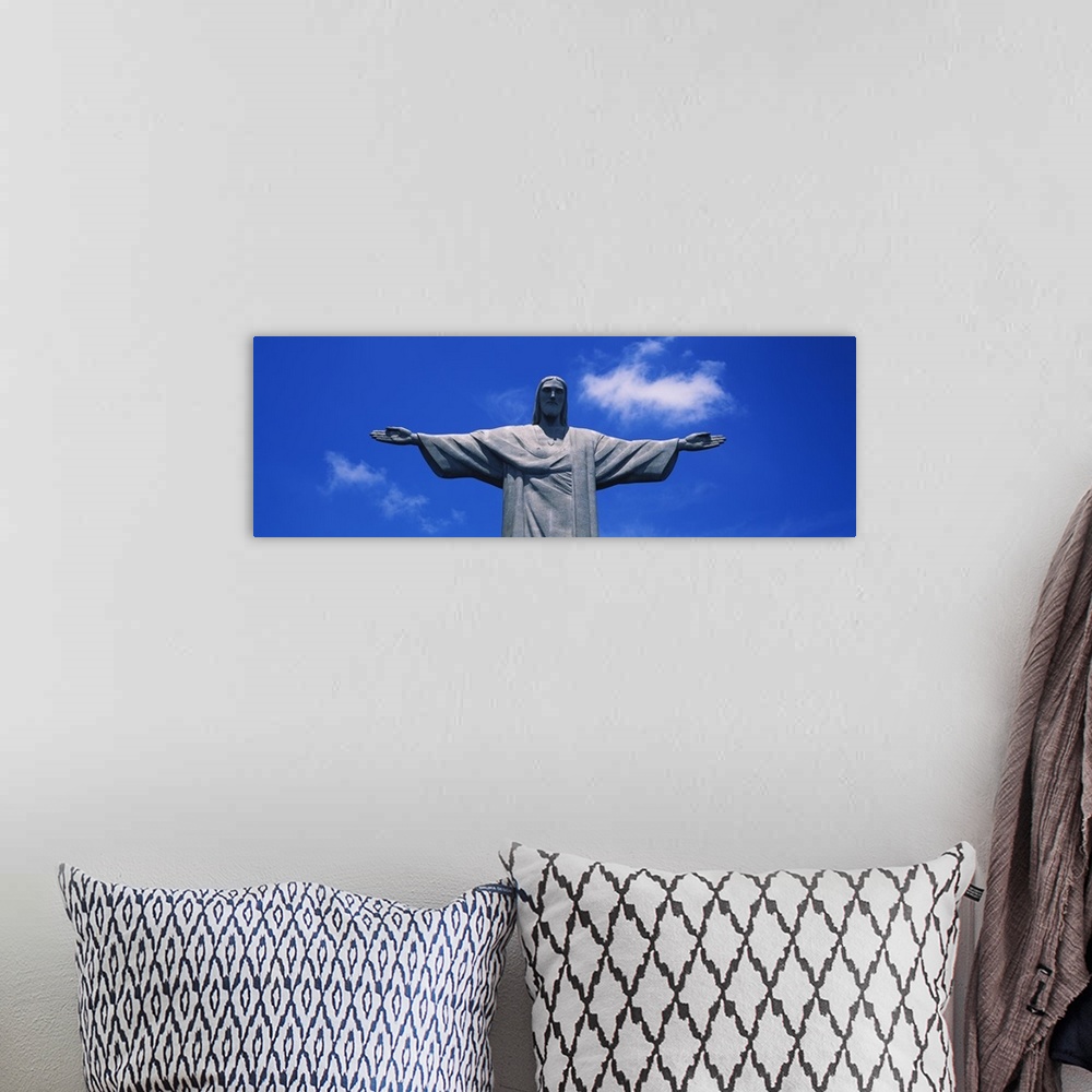A bohemian room featuring Panoramic, low angle photograph of the Christ the Redeemer statue, from the waist up, against a b...