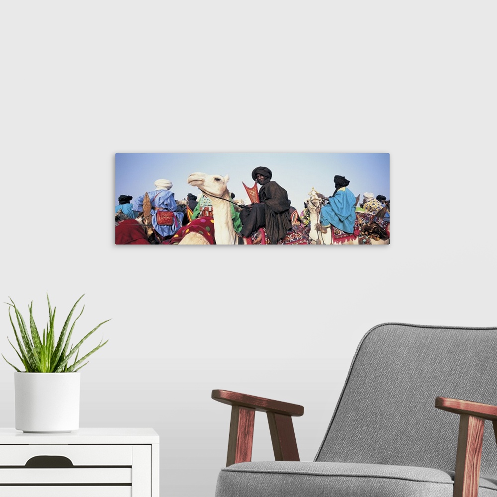 A modern room featuring Low angle view of tuaregs riding on camels, Mali