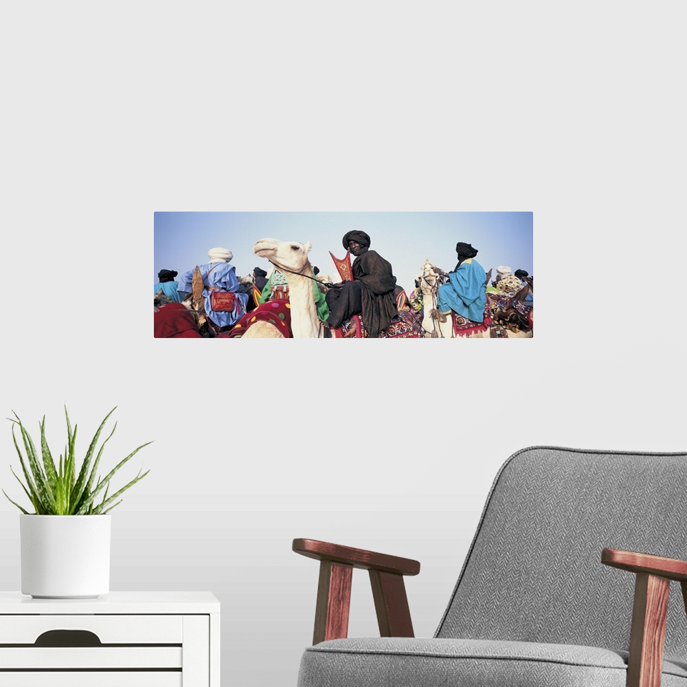 A modern room featuring Low angle view of tuaregs riding on camels, Mali