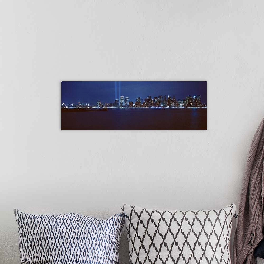 A bohemian room featuring Panoramic photograph of lit up skyline and waterfront at night.