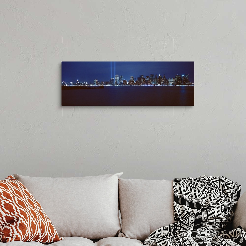 A bohemian room featuring Panoramic photograph of lit up skyline and waterfront at night.