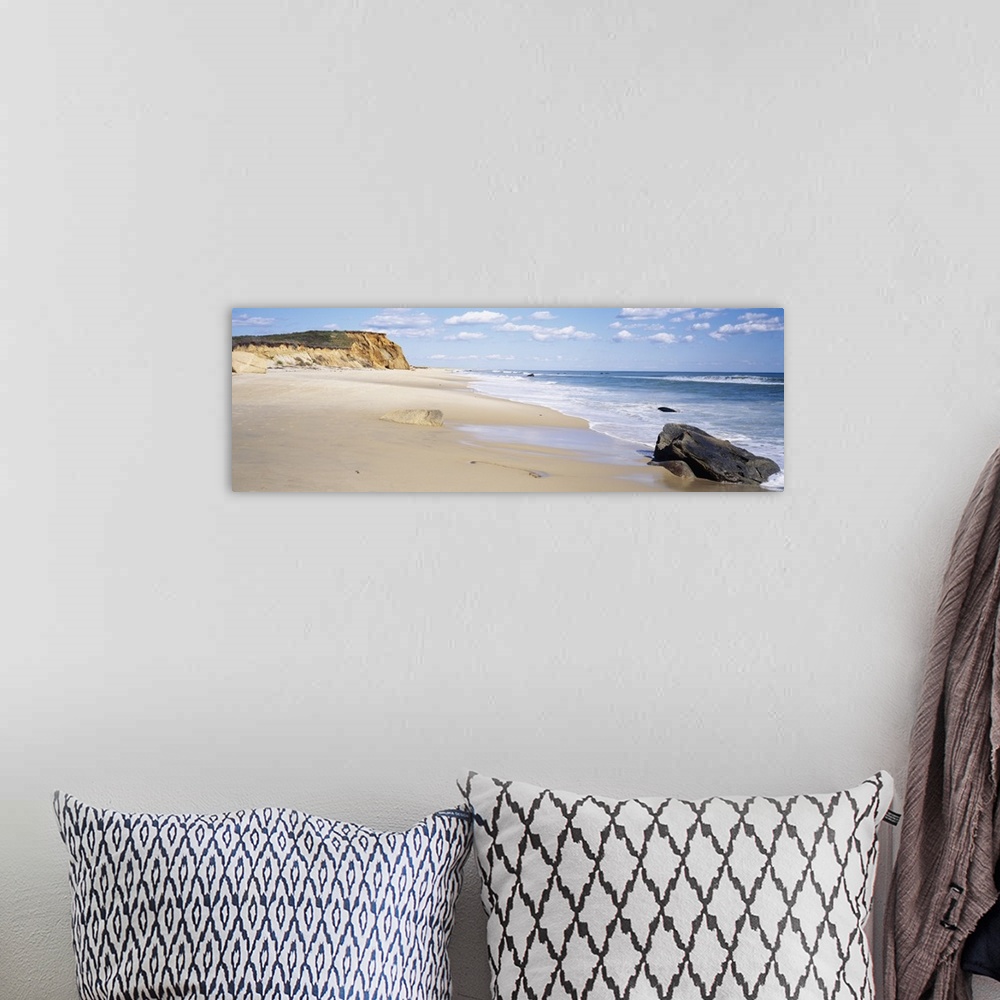 A bohemian room featuring Panoramic photograph of shoreline with surf, large rock, and cliff in the distance under a cloudy...