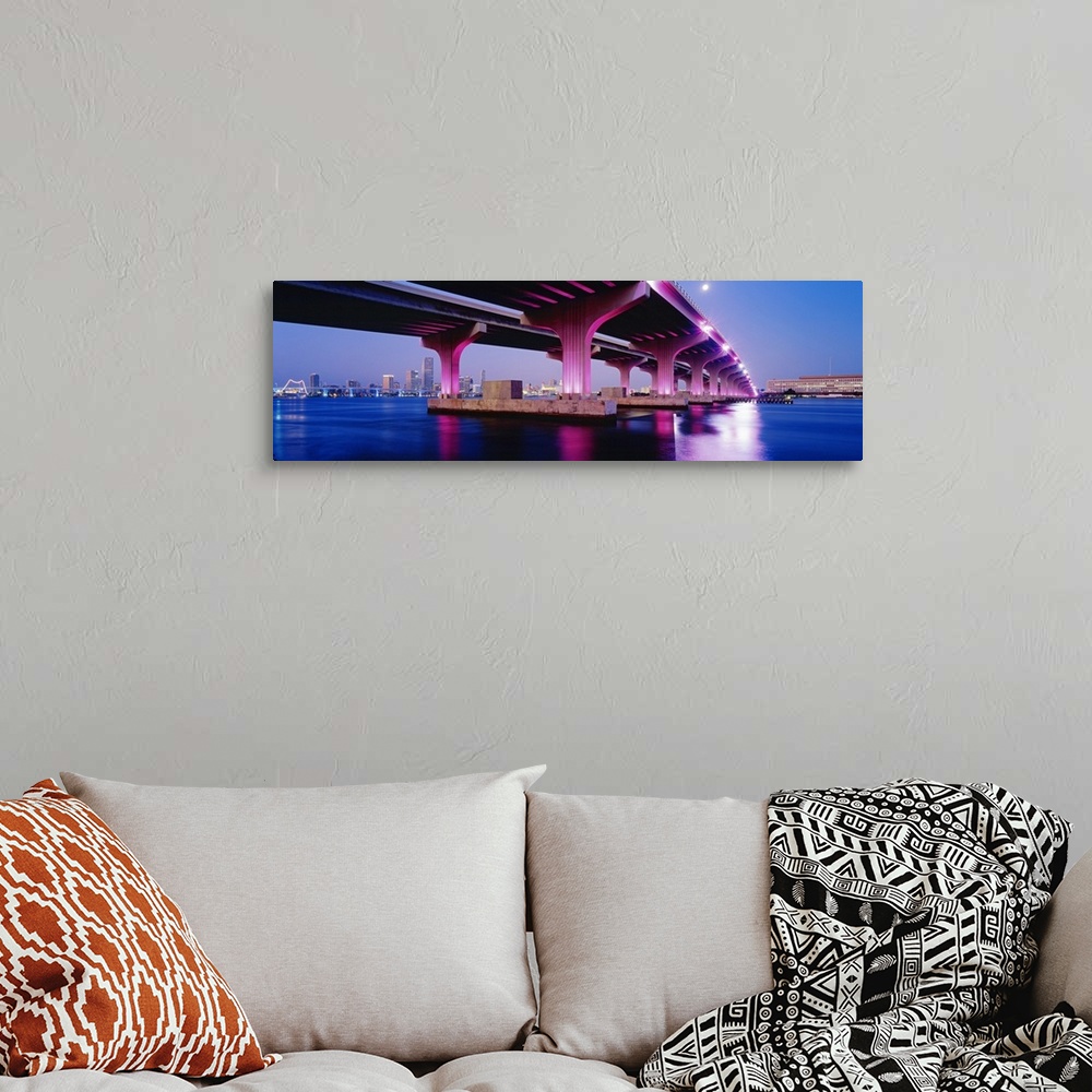 A bohemian room featuring Panoramic photograph on a big canvas of the MacArthur Causeway, lit up at night and reflecting in...