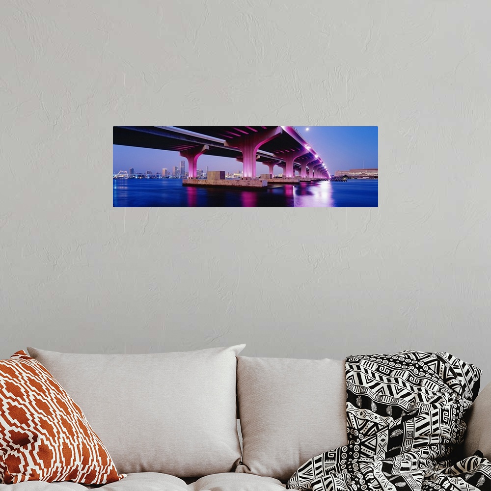 A bohemian room featuring Panoramic photograph on a big canvas of the MacArthur Causeway, lit up at night and reflecting in...