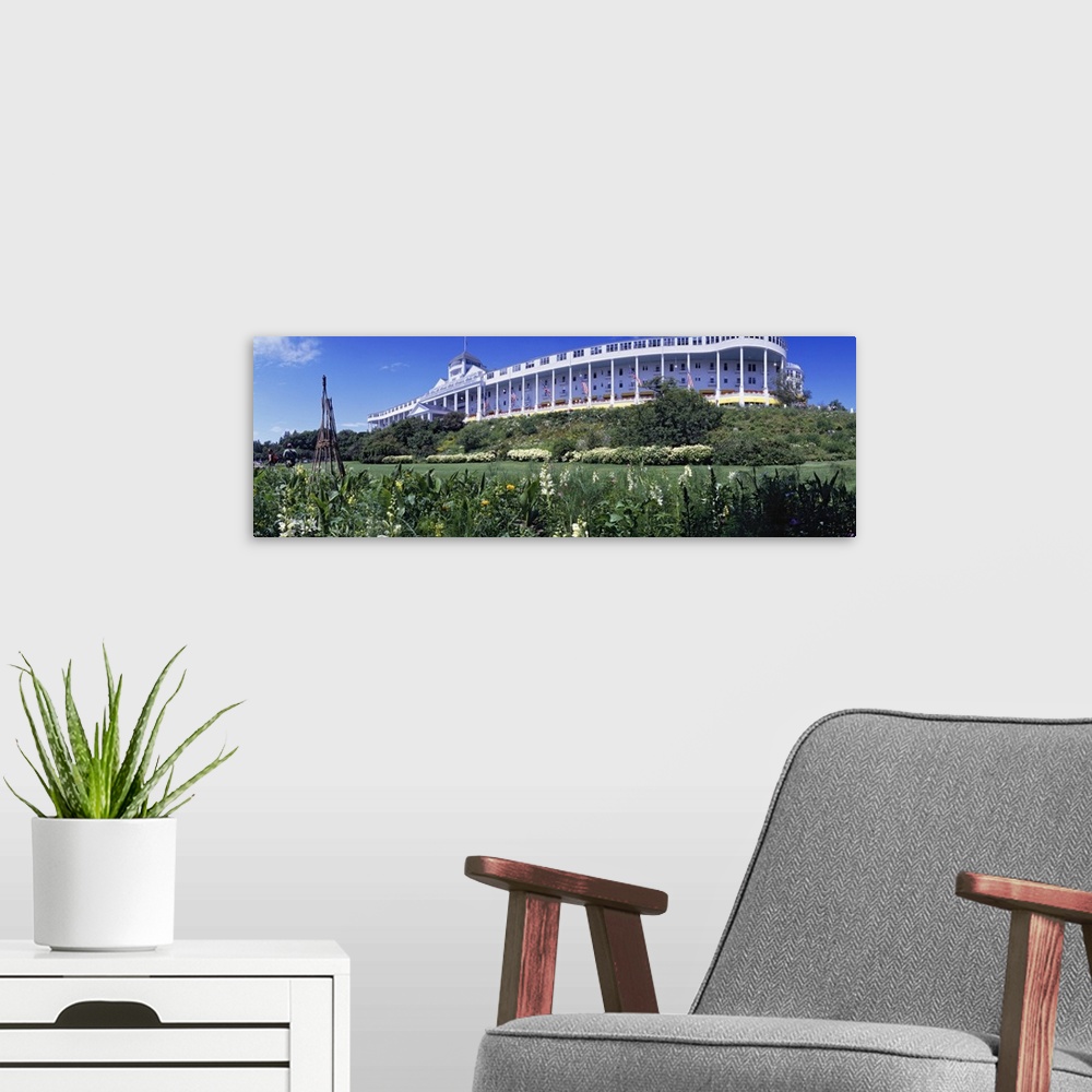 A modern room featuring Panoramic photograph of huge building with columns with flower meadow in the foreground under a c...