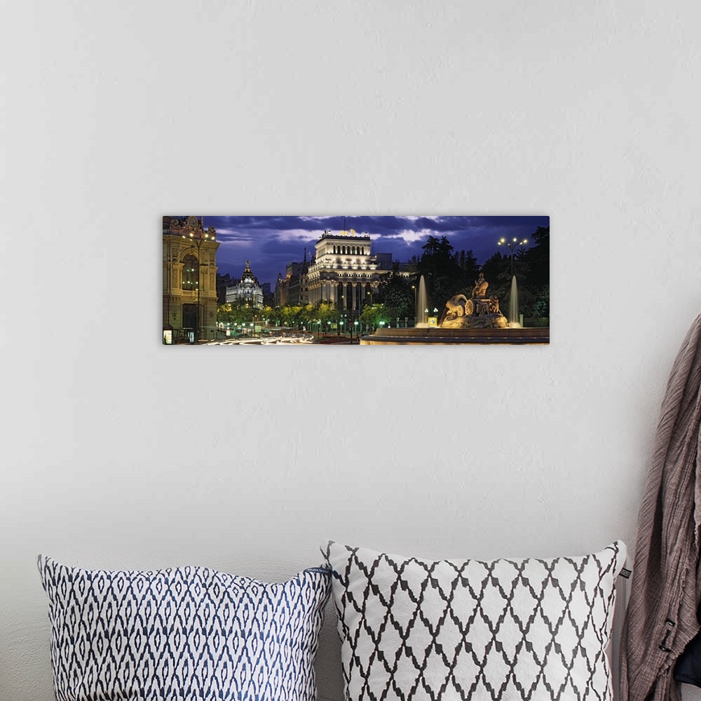 A bohemian room featuring Panoramic photo of old Spanish buildings around a traffic circle with long exposed car lights goi...