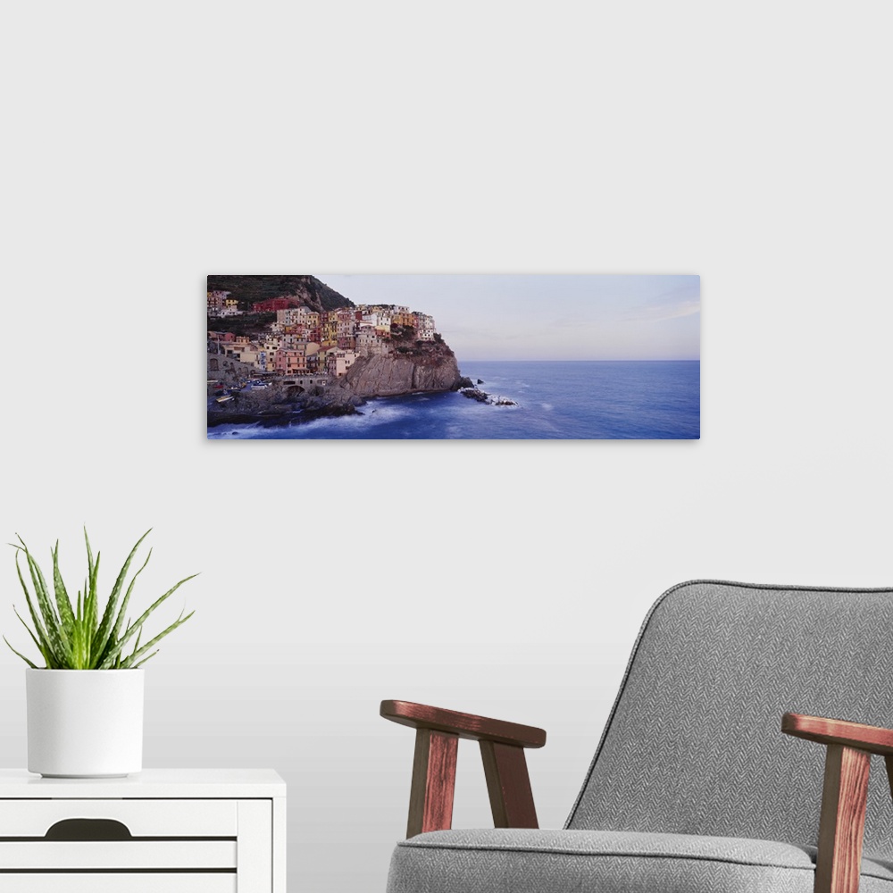 A modern room featuring Panoramic photograph of colorful city on cliffs overlooking ocean.