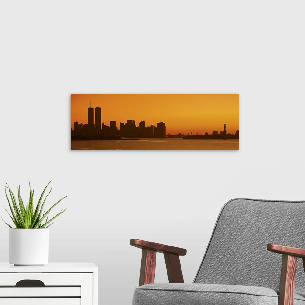 A modern room featuring Panoramic photo of the silhouette of the NYC cityscape against a warm sunset.