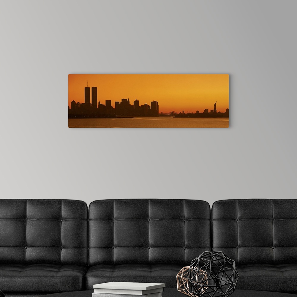 A modern room featuring Panoramic photo of the silhouette of the NYC cityscape against a warm sunset.