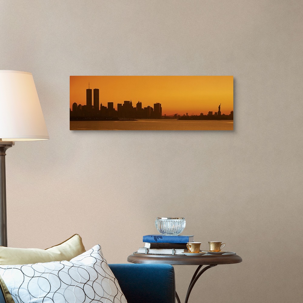 A traditional room featuring Panoramic photo of the silhouette of the NYC cityscape against a warm sunset.