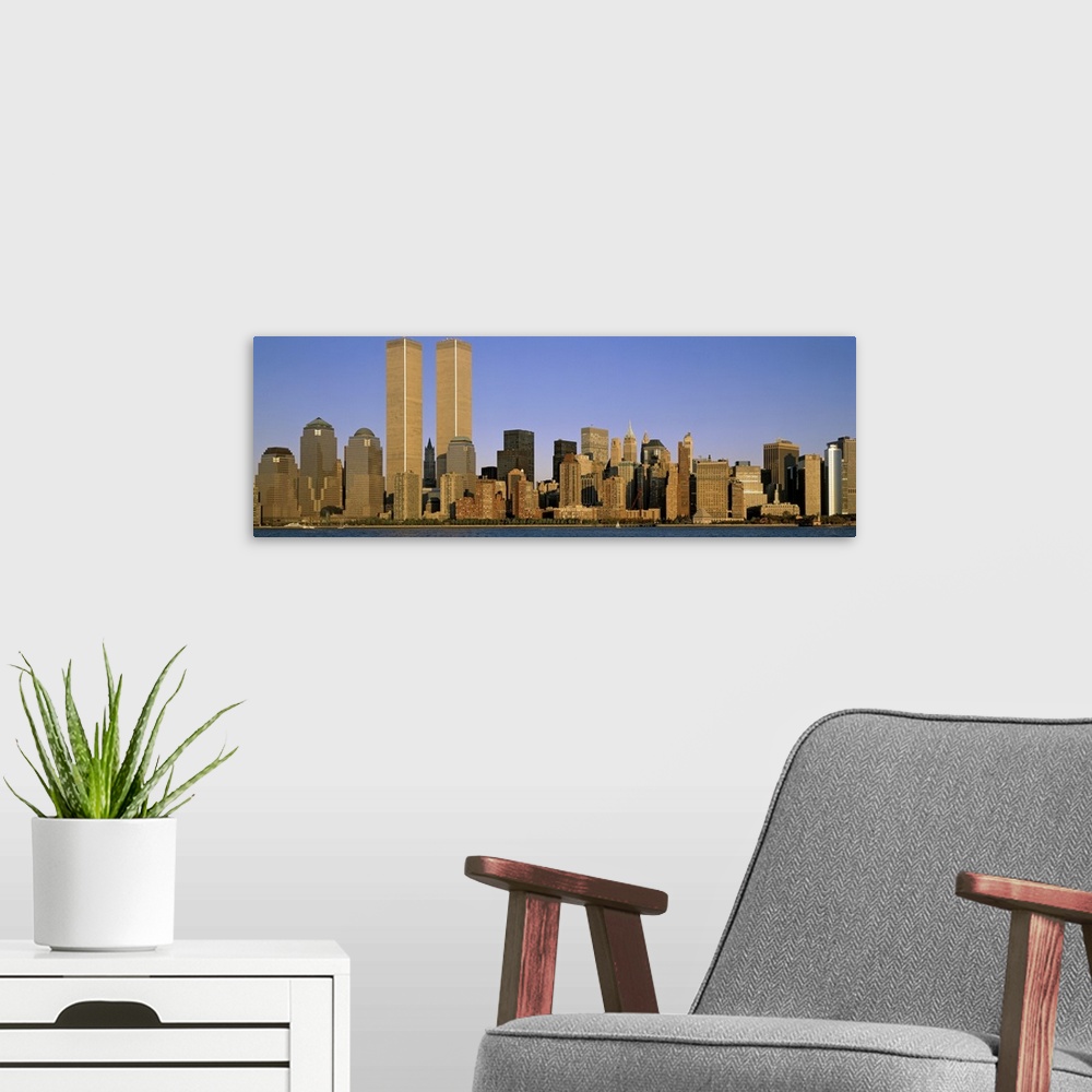A modern room featuring The Manhattan skyline is pictured in an elongated view at the end of the day when the sun is begi...