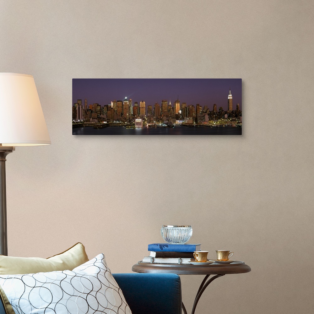 A traditional room featuring Wide angel, distant photograph of the Manhattan skyline, lit at night, beneath a deep purple sky ...