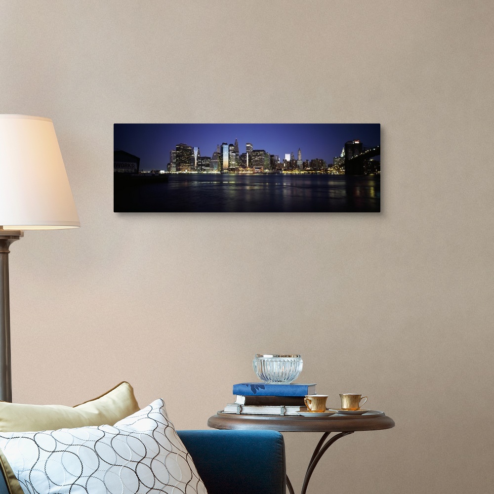 A traditional room featuring Panoramic photo of the NYC cityscape lit up at night seen from the water.