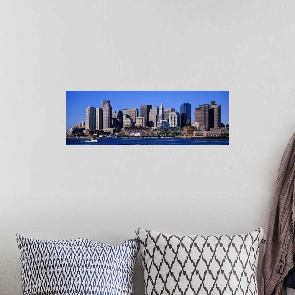 A bohemian room featuring A boat sailing across the water in front of the Boston skyline in Massachusetts.