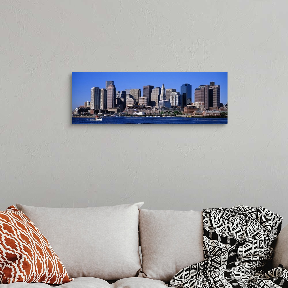 A bohemian room featuring A boat sailing across the water in front of the Boston skyline in Massachusetts.