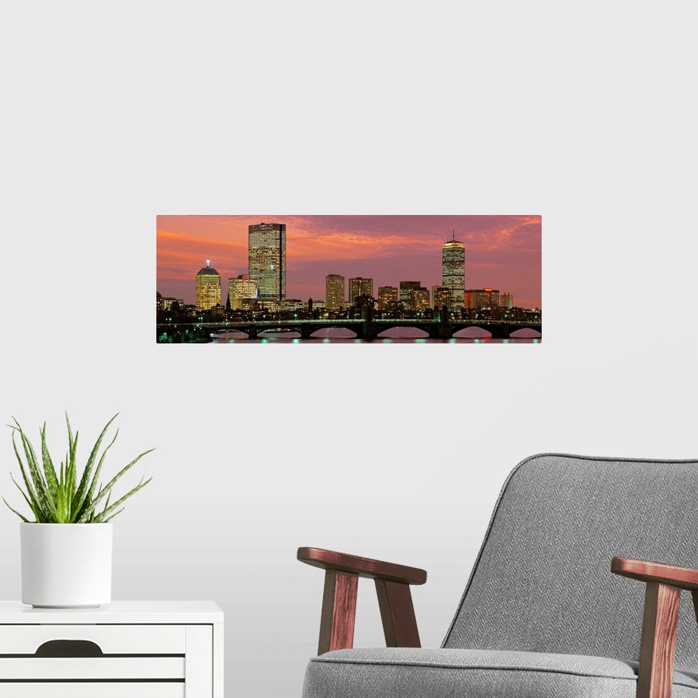 A modern room featuring Large horizontal wall picture of the Boston city skyline at dusk with the Charles River Bridge in...