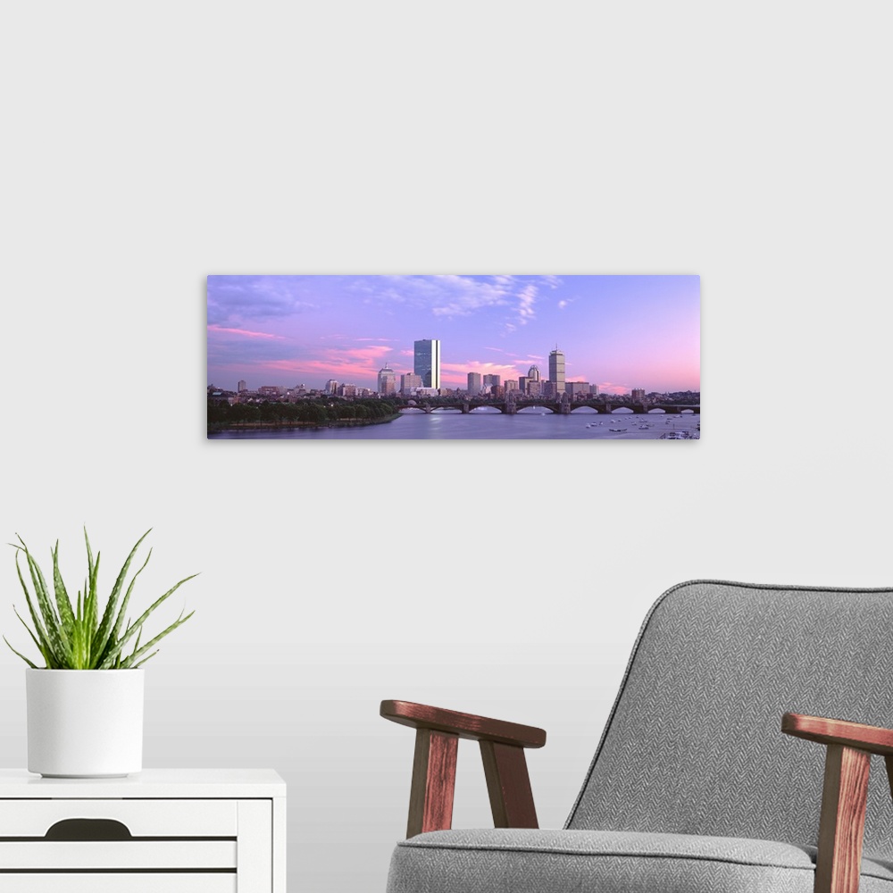 A modern room featuring Landscape photograph of the Boston skyline beneath a vibrant sky at dusk, the Longfellow Bridge o...
