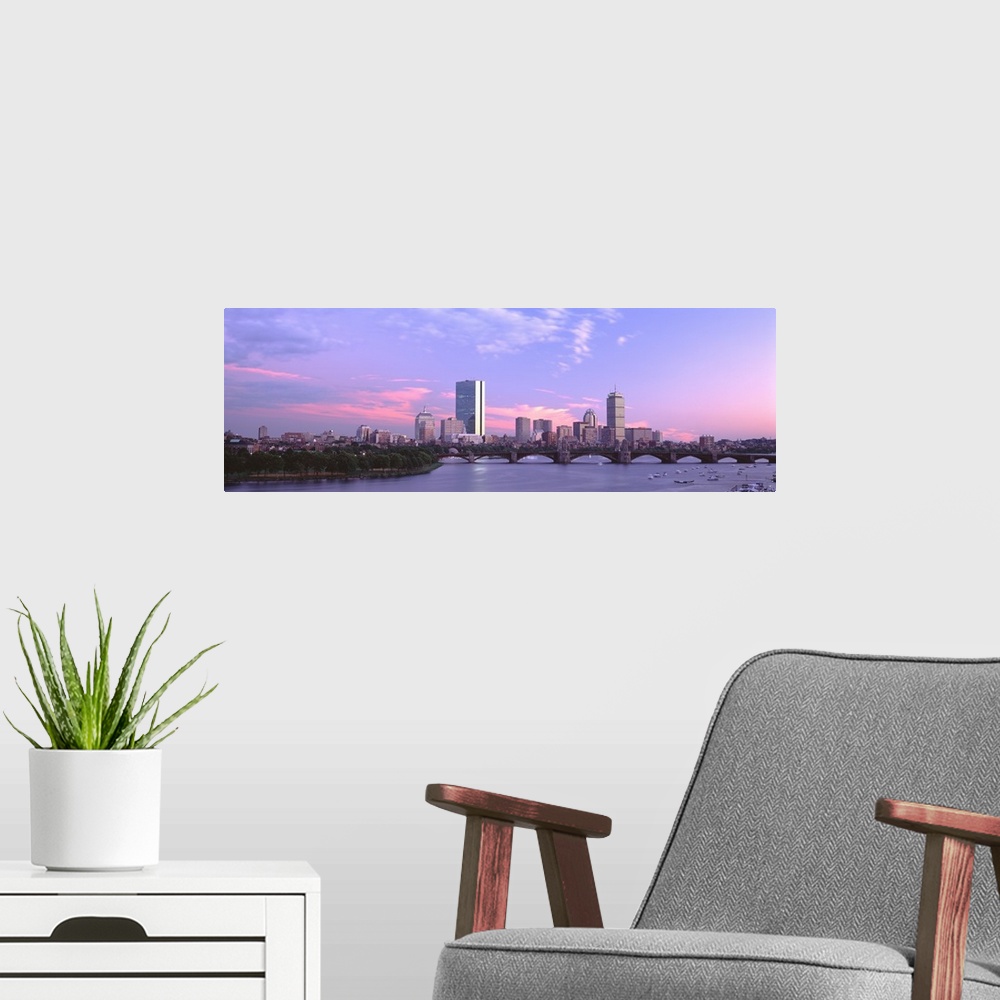 A modern room featuring Landscape photograph of the Boston skyline beneath a vibrant sky at dusk, the Longfellow Bridge o...