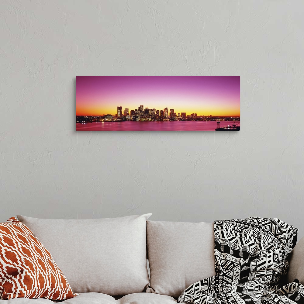 A bohemian room featuring Big, wide angle photograph of a distant Boston skyline, with lit skyscrapers at sunset.